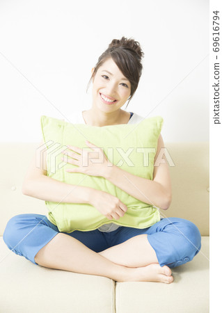 Woman sitting on the couch Woman sitting on the couch 69616794