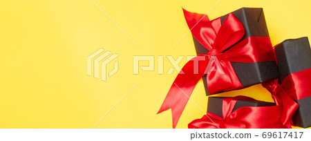 Black friday sale flat lay with gift box and ribbon, copy space, christmas and holidays concept on yellow background Black friday sale flat lay with gift box and ribbon, copy space, christmas and holidays concept on yellow background 69617417