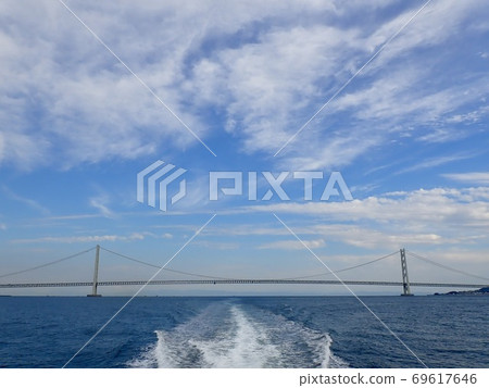 A bridge seen from a ship traveling in the Seto Inland Sea under a clear blue sky 69617646
