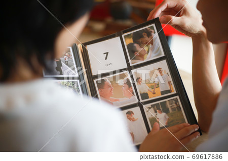 Couple watching the album Couple watching the album 69617886