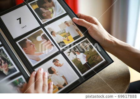Couple watching the album Couple watching the album 69617888