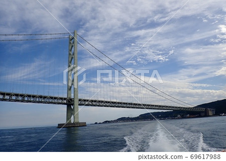 從渡過明石海峽的船在藍天下看到的淡路島和大橋 從渡過明石海峽的船在藍天下看到的淡路島和大橋 69617988