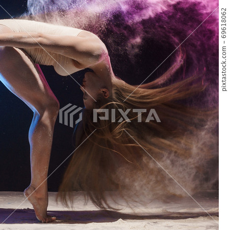 Graceful female gymnast in cloud of color dust 69618062