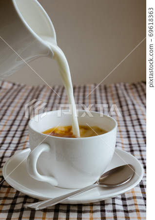 Pouring Milk into a Cup of Tea. Pouring Milk into a Cup of Tea. 69618363