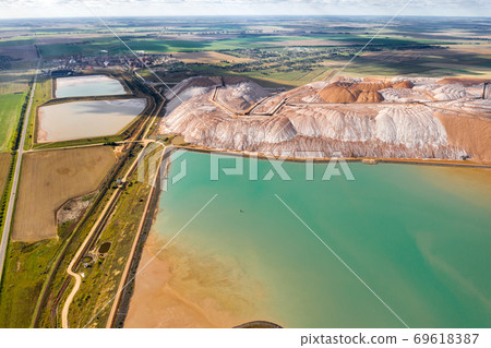 Mountains of products for the production of potash salt and artificial turquoise reservoirs.Salt mountains near the city of Soligorsk.Production of fertilizers for the Land. Belarus Mountains of products for the production of potash salt and artificial turquoise reservoirs.Salt mountains near the city of Soligorsk.Production of fertilizers for the Land. Belarus 69618387