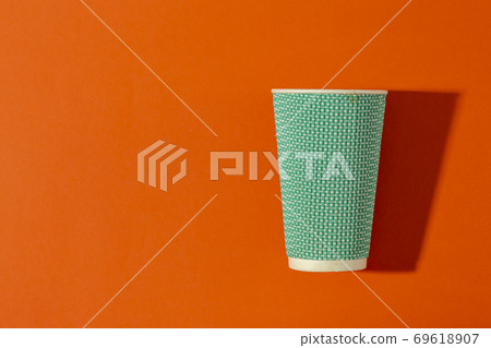 Paper cup for coffee on an orange background. 69618907