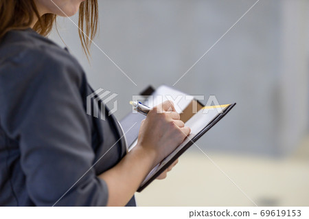 A woman taking a note 69619153