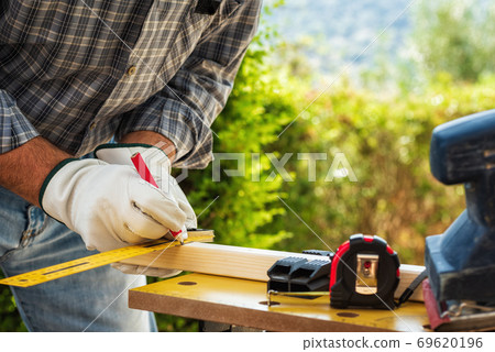 Carpenter at work on wooden boards. Carpentry. 69620196