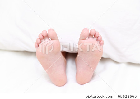 赤腳的一個女孩在床上睡覺 69622669