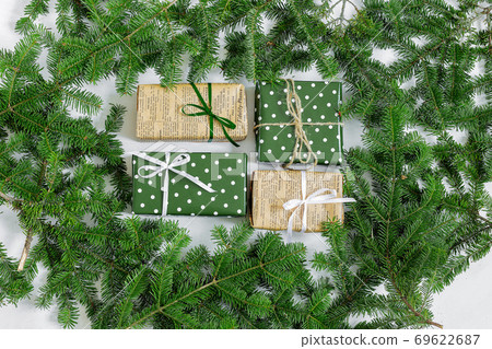 New Year's gifts on the background of a Christmas tree. New Year's gifts on the background of a Christmas tree. 69622687