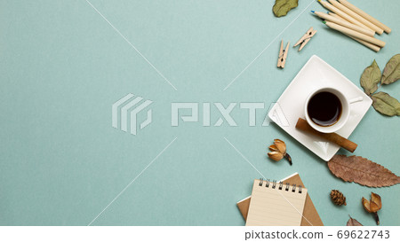Autumn concept. Notebook and black coffee with dry leaves on green background. flat lay, top view, copy space. Work and study place 69622743
