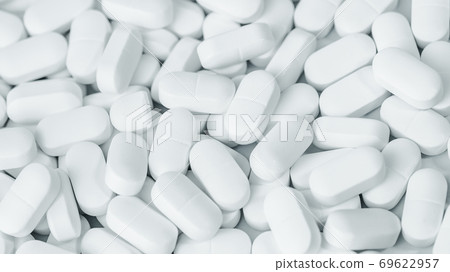 Background of white tablets or pills on the table. Medicine and pharmacy Background of white tablets or pills on the table. Medicine and pharmacy 69622957