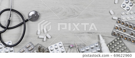 Medicine. Pills with phonendoscope on grey wood Medicine. Pills with phonendoscope on grey wood 69622960