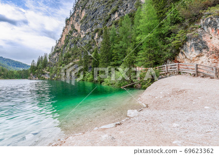 The shores of the famous Alpine Lake Braies with crystal emerald water 69623362