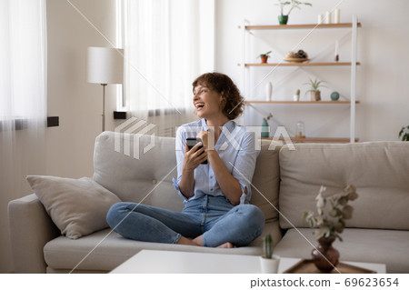 Happy Caucasian woman laugh using smartphone gadget 69623654