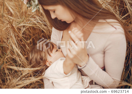Elegant mother with cute little daughter in a field 69623714