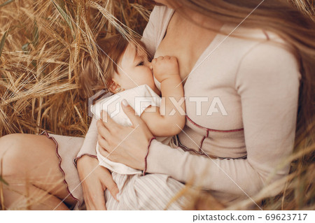 Elegant mother with cute little daughter in a field Elegant mother with cute little daughter in a field 69623717