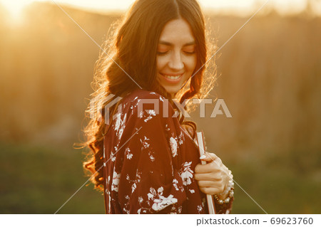 Stylish woman spending time in a summer field Stylish woman spending time in a summer field 69623760
