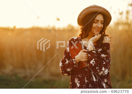 Stylish woman spending time in a summer field Stylish woman spending time in a summer field 69623770
