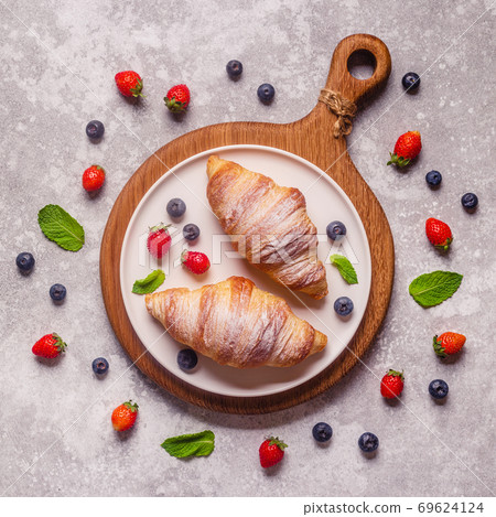 Breakfast with croissants and fresh fruits. 69624124