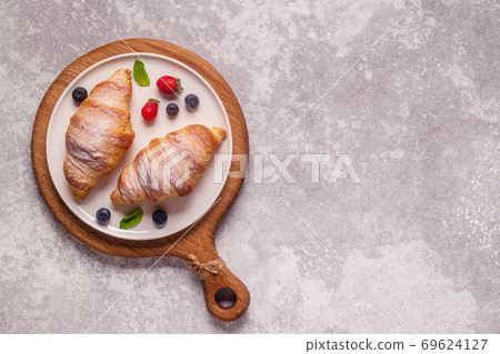 Breakfast with croissants and fresh fruits. 69624127
