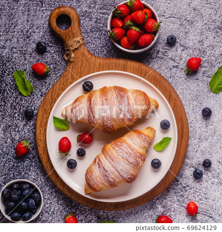 Breakfast with croissants and fresh fruits. Breakfast with croissants and fresh fruits. 69624129