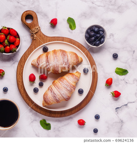 Breakfast with croissants and fresh fruits. Breakfast with croissants and fresh fruits. 69624136