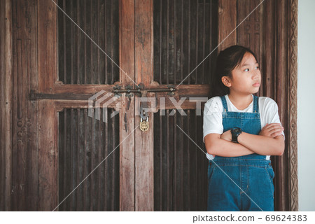 portrait of young girl stand at old wood door, 69624383