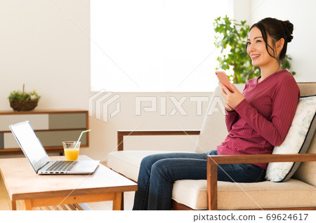 A woman who takes a break with a smartphone between telework A woman who takes a break with a smartphone between telework 69624617