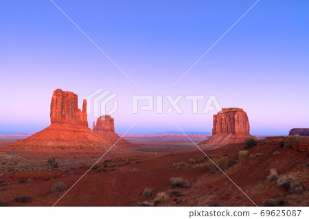 The last rays of the setting sun illuminate famous Buttes of Monument Valley 69625087