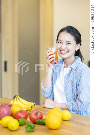 Image of a woman enjoying fruit (fruit juice) at home 69625314