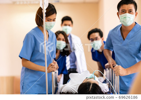 Medical team push gurney with injured patient 69626186