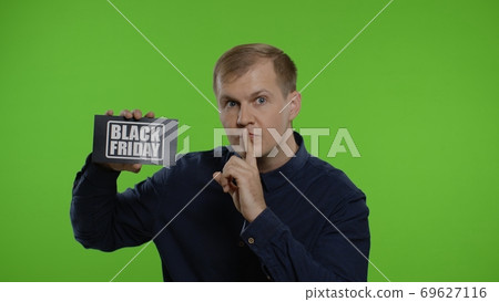 Man showing Black Friday inscription, putting finger on lips making silence gesture. Chroma key Man showing Black Friday inscription, putting finger on lips making silence gesture. Chroma key 69627116