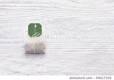 Tea bag on a white wooden table. Close-up 69627508