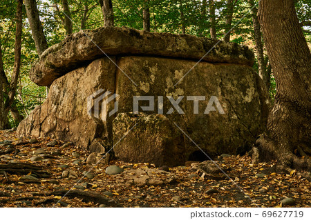ancient megalith dolmen among trees in an autumn grove ancient megalith dolmen among trees in an autumn grove 69627719