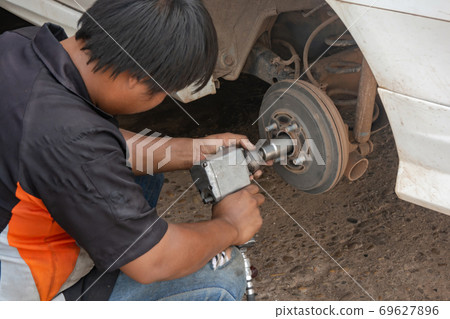 The mechanic repair drum brake of car The mechanic repair drum brake of car 69627896