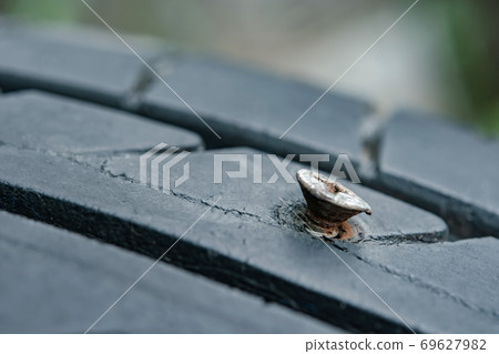 Close up metal screws nails embroidered in tires. 69627982