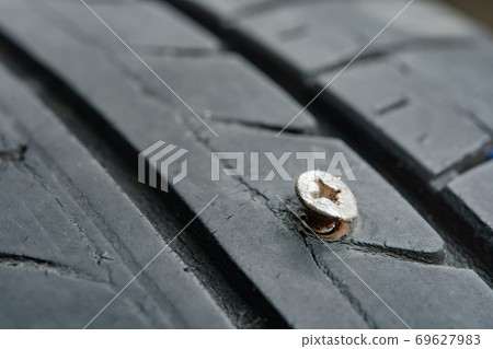 Close up metal screws nails embroidered in tires. 69627983