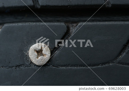 Close up metal screws nails embroidered in tires Close up metal screws nails embroidered in tires 69628003