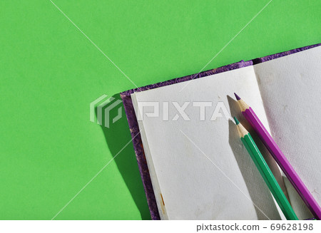 Opened notebook with colored pencils Opened notebook with colored pencils 69628198