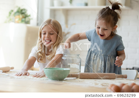 Cute girls discovering the world of cooking Cute girls discovering the world of cooking 69628299