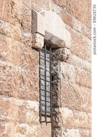 Old window with a rusty steel grate in a historic building, cathedral Old window with a rusty steel grate in a historic building, cathedral 69628730