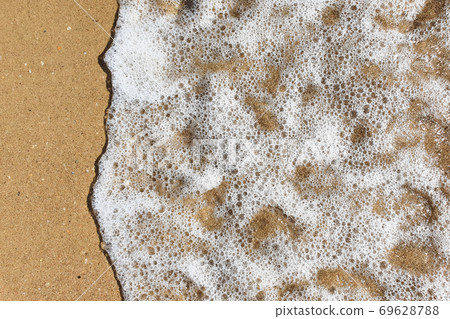 Top view of sea foam and beach sand. Sea wave. Close up. Top view of sea foam and beach sand. Sea wave. Close up. 69628788