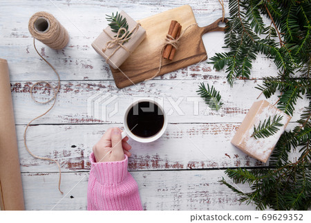 hand put cup of coffee on the table with gifts hand put cup of coffee on the table with gifts 69629352