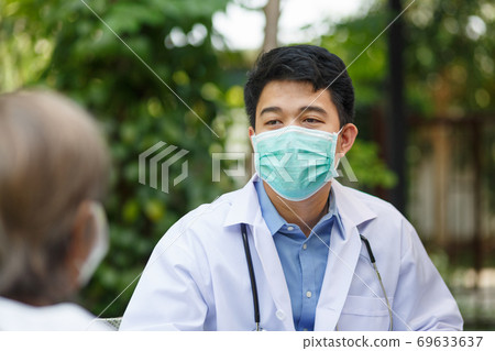 Asian doctor talking with elderly female patient on wheelchair Asian doctor talking with elderly female patient on wheelchair 69633637
