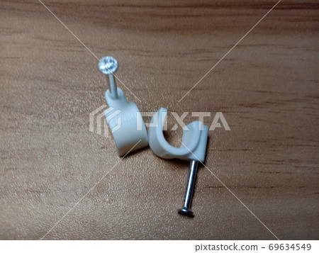 white colored wire pin on wooden table 69634549