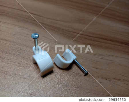 white colored wire pin on wooden table white colored wire pin on wooden table 69634550