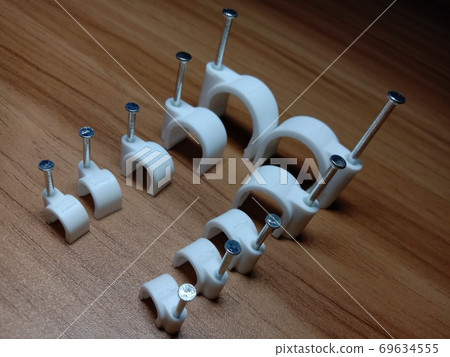 white colored wire pin on wooden table white colored wire pin on wooden table 69634555