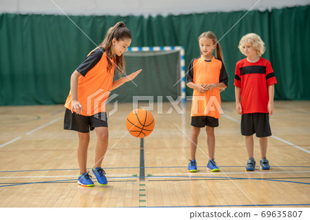 A girl playing with a ball and looking enjoyed 69635807