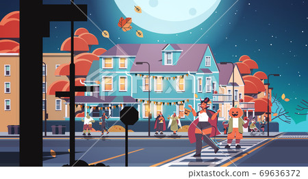people in costumes walking in town trick or treat happy halloween celebration concept greeting card 69636372